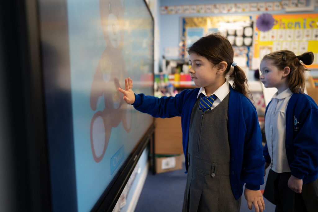 A young student using an interactive whiteboard